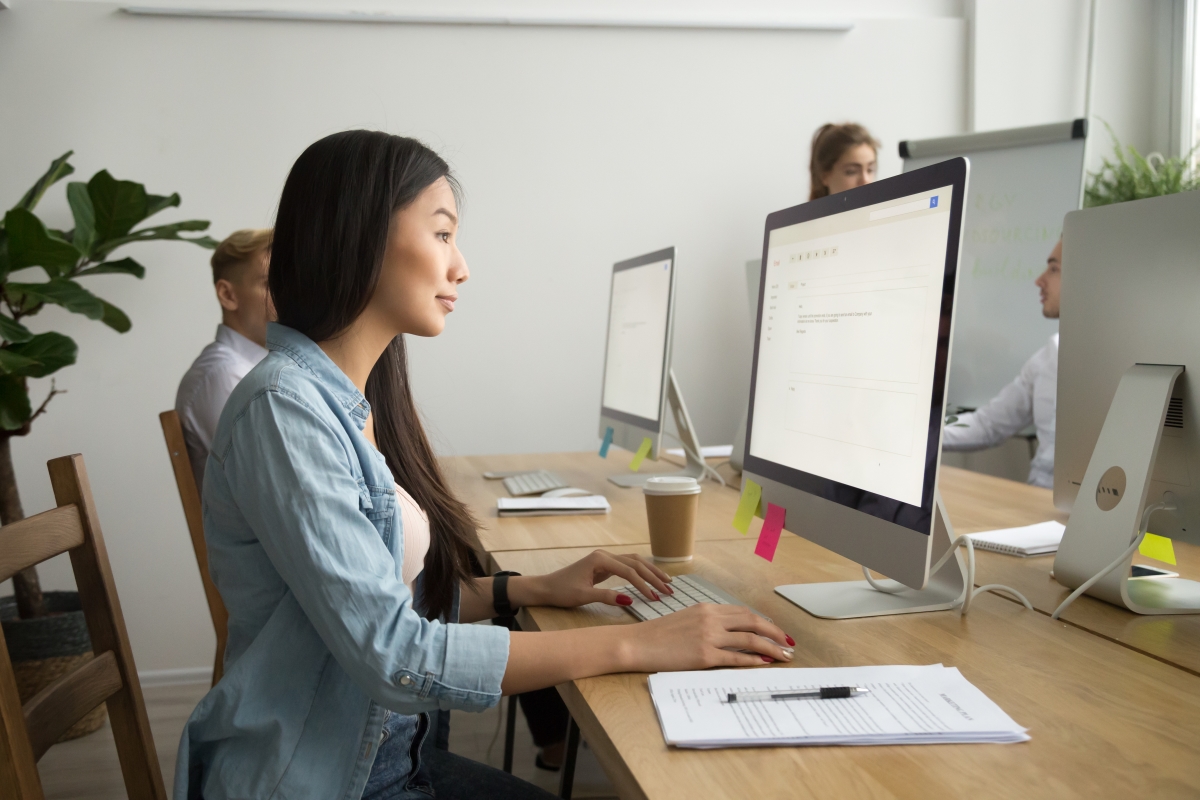 A female data entry virtual assistant working on her desktop computer